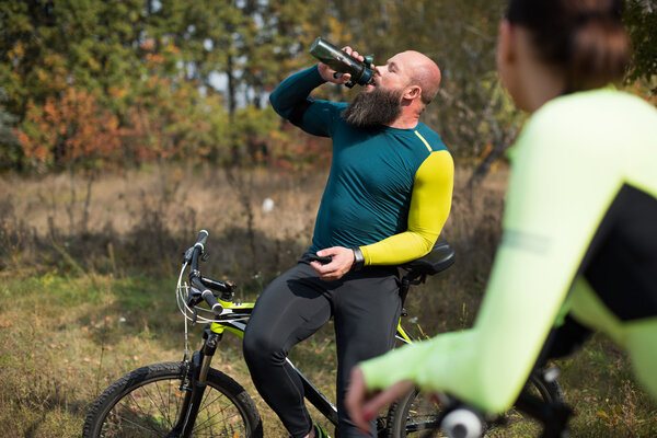 Пара велосипедистов в осеннем парке
