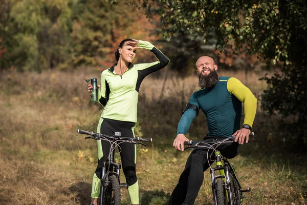 Couple of cyclists in autumn park — Stock Photo, Image