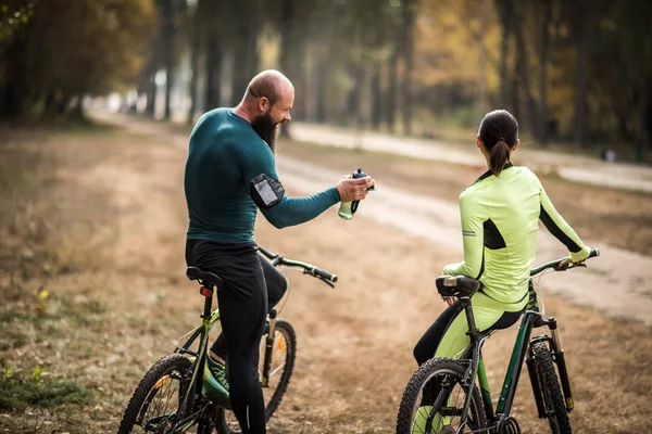 Couple of cyclists in autumn park — Free Stock Photo