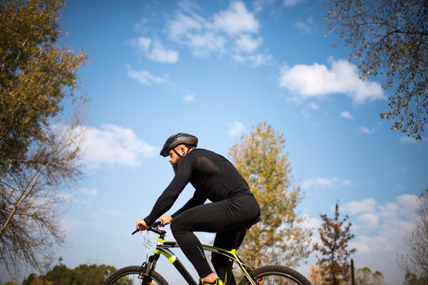 Bearded man cycling in park