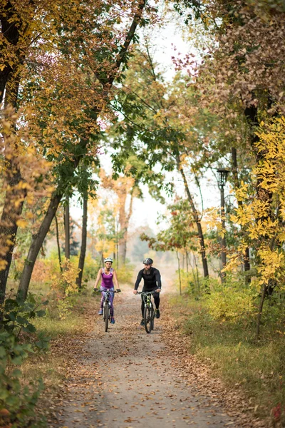 Människor cyklande i höst park — Stockfoto