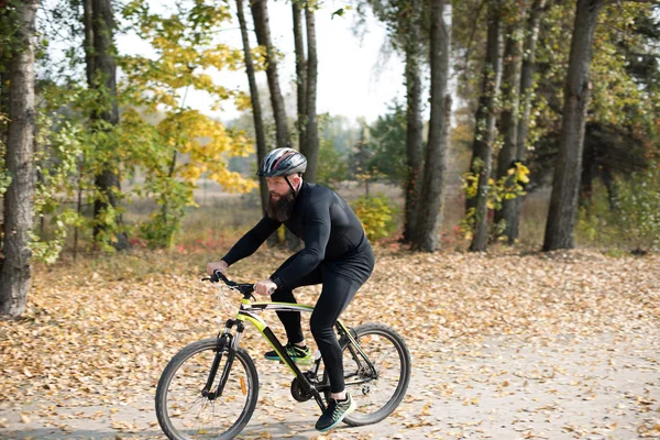 Бородатий чоловік їде на велосипеді в парку — стокове фото