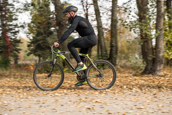 Bebaarde man fietsen in park — Stockfoto