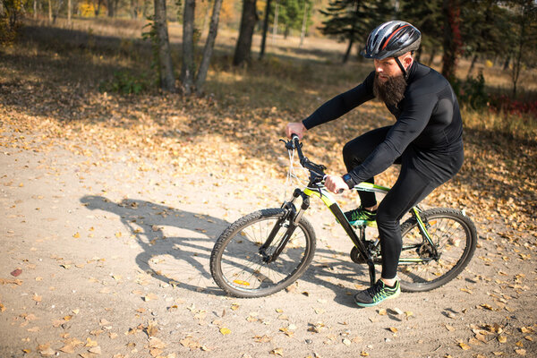 Bearded man cycling in park