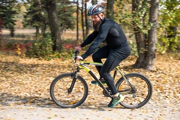 ひげを生やした男が公園でサイクリング — ストック写真