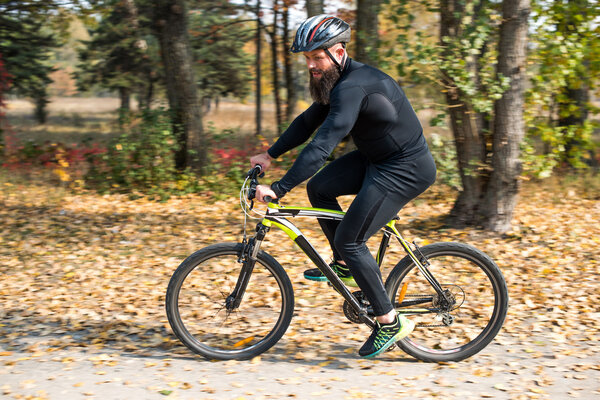 Bearded man cycling in park