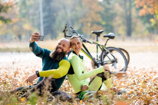 Un par de ciclistas tomando selfie — Foto de Stock