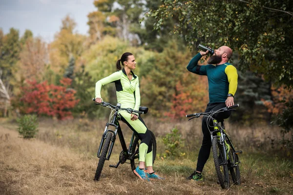 Couple of cyclists in autumn park — Free Stock Photo