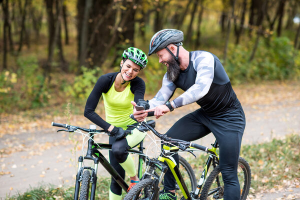 Бородатый мужчина показывает смартфон девушке
