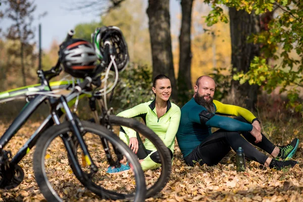 Rowery i para rowerzystów w parku — Zdjęcie stockowe