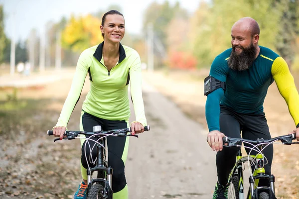 Uśmiechający się para, jazda na rowerze w parku — Zdjęcie stockowe