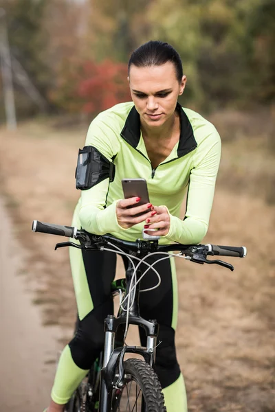 Radfahrerin nutzt Smartphone — Stockfoto