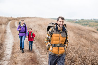 Man with wife and son backpacking clipart