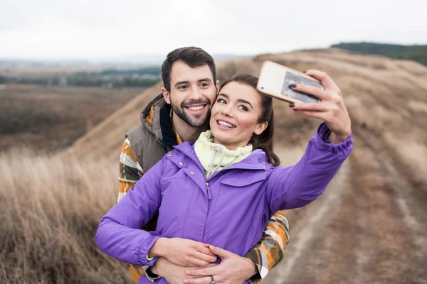 Couple taking selfie on rural path — Stock fotografie