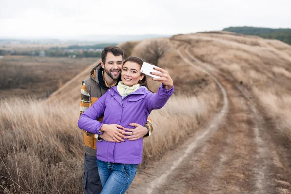 Couple taking selfie on rural path — Stock fotografie