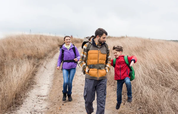 Happy family with backpacks walking — Stockfoto