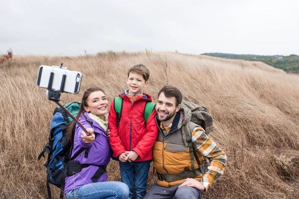 Família feliz com mochilas tirando selfie — Fotografia de Stock