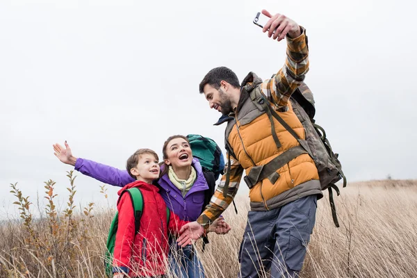 Família feliz com mochilas tirando selfie — Fotografia de Stock