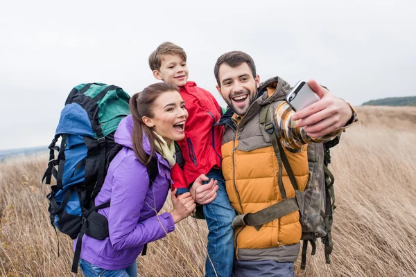 Happy family with backpacks taking selfie — ストック写真