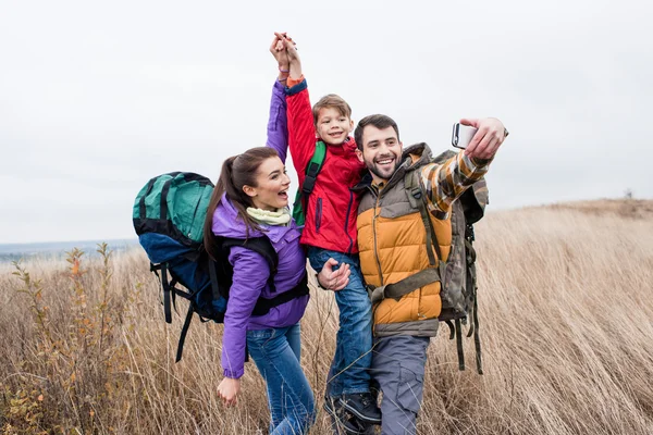 Happy family with backpacks taking selfie — Stock Photo, Image