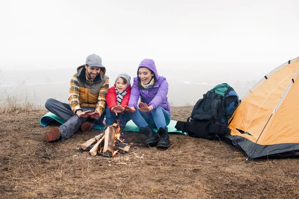 Famiglia felice guardando il fuoco ardente — Foto Stock