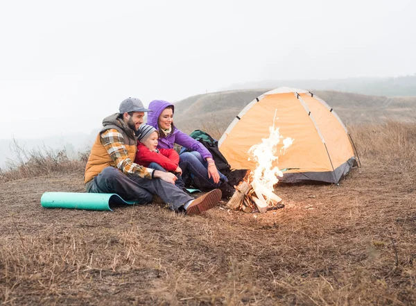 Glückliche Familie schaut auf brennendes Feuer — Stockfoto