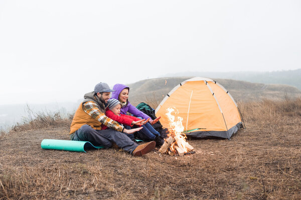 Happy family looking at burning fire