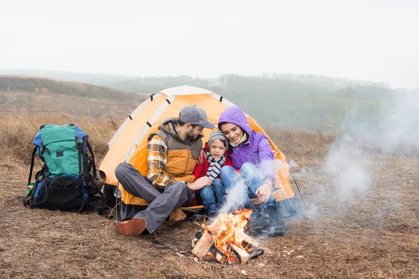 Happy family looking at burning fire — Stock Photo, Image