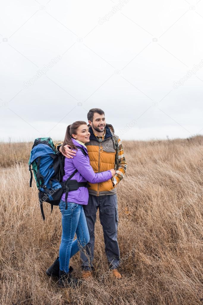 Happy young couple with backpacks