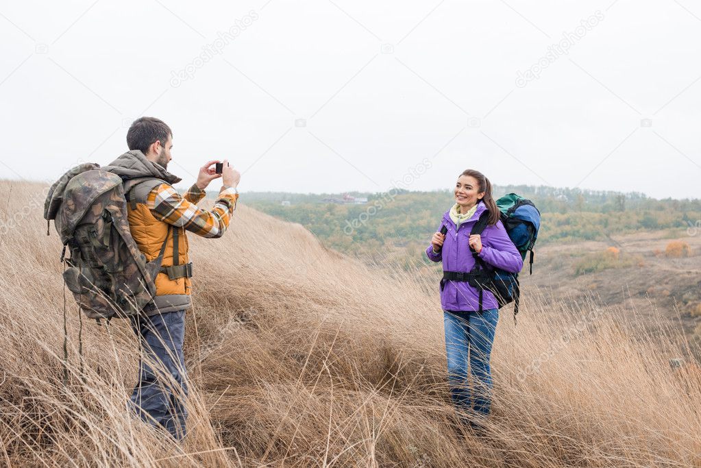 Man photographing woman during walking tour