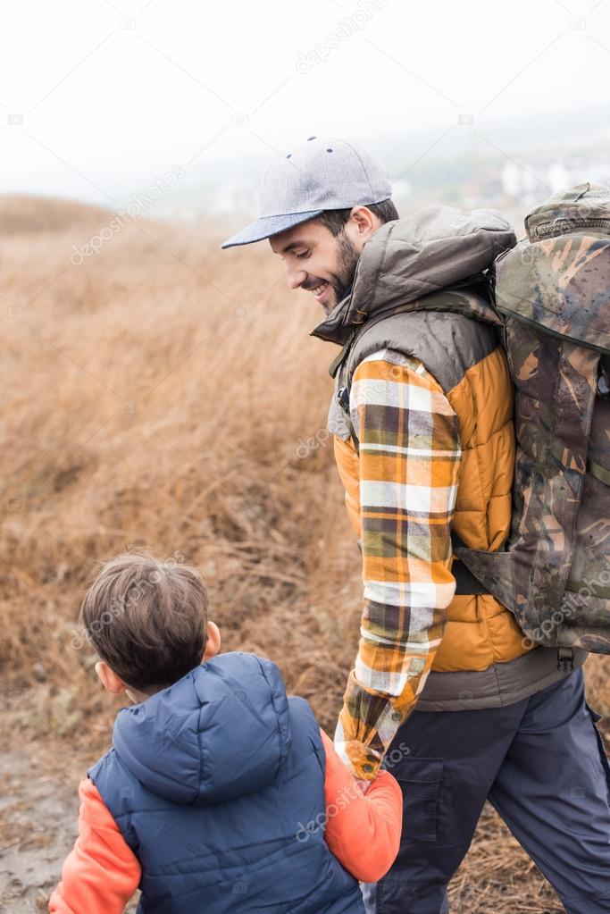 Smiling father backpacker with son