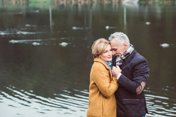 Hermosa pareja madura de pie cerca del lago —  Fotos de Stock