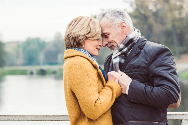 Hermosa pareja madura de pie cerca del lago — Foto de Stock