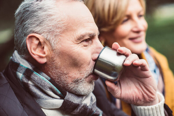 Mature couple drinking tea in park