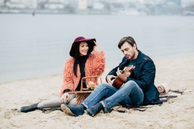 Adam açık havada pikniğinde gitar çalmak