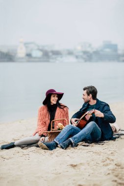 Adam açık havada pikniğinde gitar çalmak