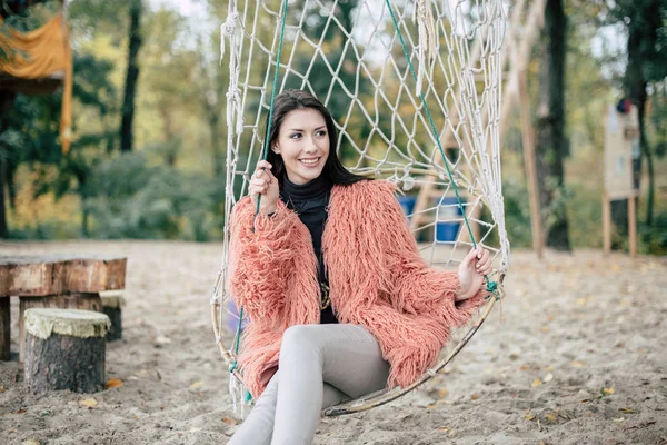 Aantrekkelijke vrouw zitten in netto schommel — Stockfoto