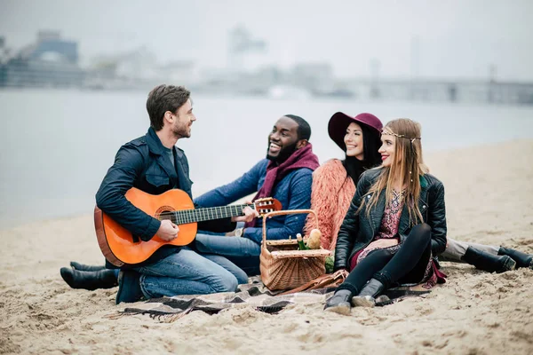 Happy friends with guitar at picnic — Stock Photo, Image