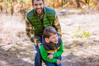Happy father and son in park clipart
