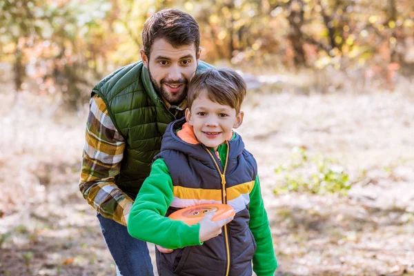 Leende far och son leker med frisbee — Gratis stockfoto