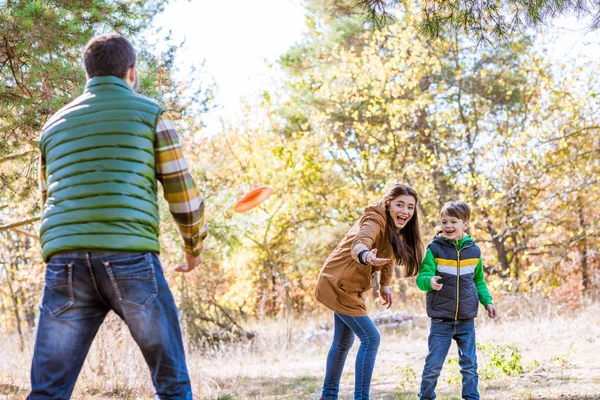 Šťastná rodina hraje s frisbee — Stock fotografie