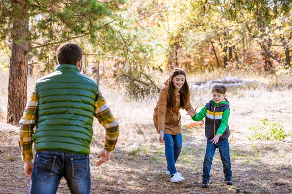 Glückliche Familie spielt mit Frisbee lizenzfreie Stockbilder