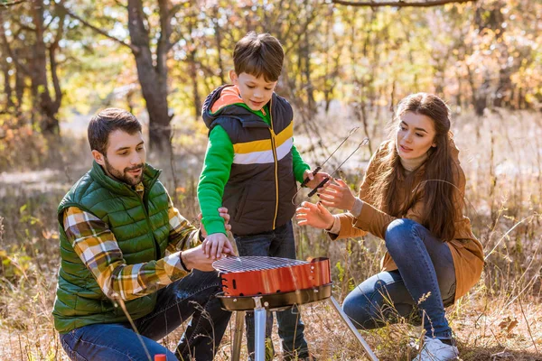 Happy family preparing barbecue in park — Stock Photo, Image