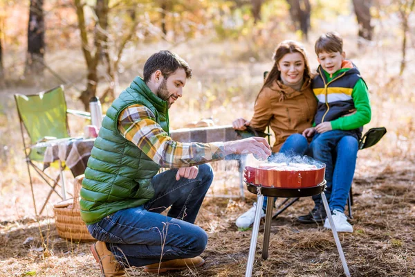 Family grilling meat on barbecue — Stock Photo, Image