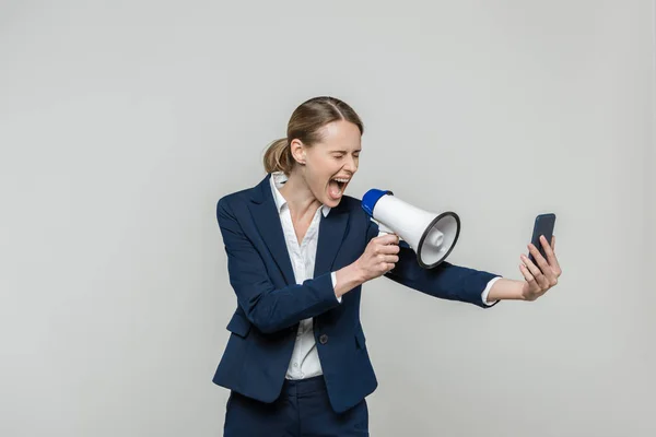Businesswoman with smartphone and loudspeaker — Stock Photo, Image