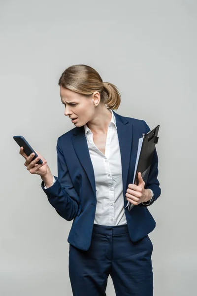 Заплутана бізнес-леді зі смартфоном Ліцензійні Стокові Зображення