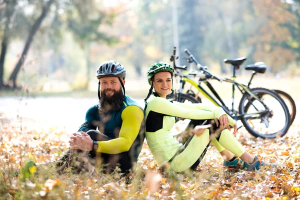 Ciclisti che riposano vicino alle biciclette — Foto stock