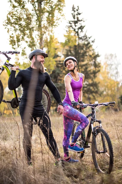 Ciclistas con bicicletas en el parque de otoño - foto de stock