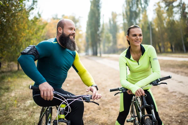 Casal de ciclistas no parque de outono — Fotografia de Stock