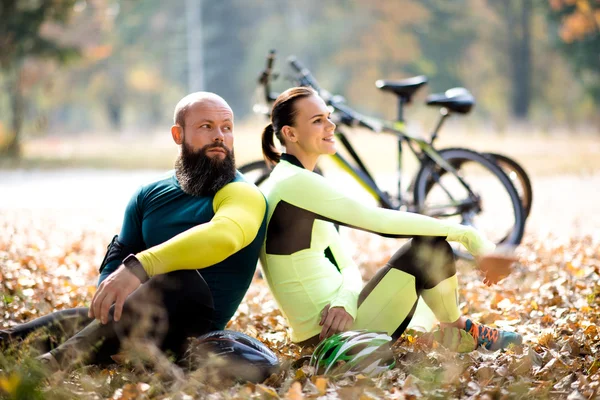 Ciclisti che riposano sul prato asciutto autunnale — Foto stock